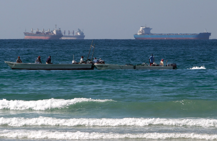 Fishermen work in front of oil tankers south of the Strait of Hormuz Jan. 19, 2012. Kamran Jebreili/AP Photo