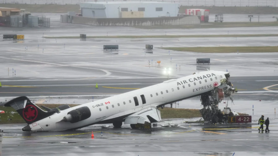 Investigators walk the site where an Air Canada jet came to rest after colliding with a Port Authority fire truck at LaGuardia Airport in New York City the previous night, on March 23, 2026. (Seth Wenig/AP Photo)