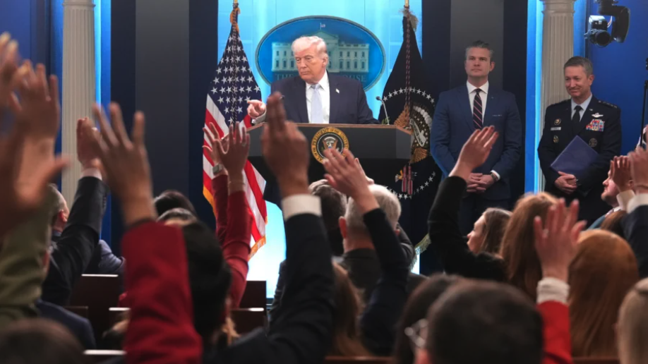 President Donald Trump speaks with reporters during a news conference in the James Brady Press Briefing Room at the White House on April 6, 2026, as Secretary of War Pete Hegseth and Chairman of the Joint Chiefs of Staff Gen. Dan Caine listen. (Mark Schiefelbein/AP Photo)