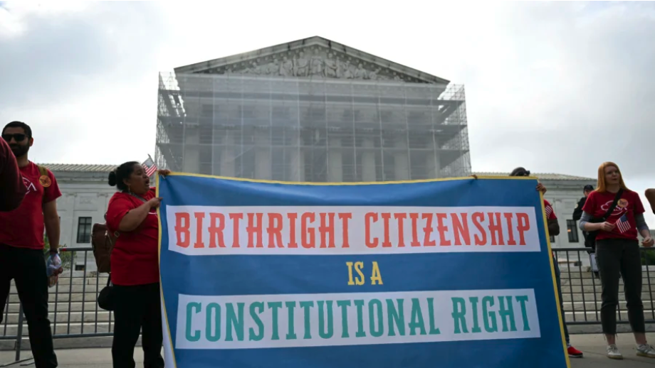 People hold a sign as they participate in a protest outside the U.S. Supreme Court over President Donald Trump’s move to end birthright citizenship as the court hears arguments over the order in Washington on May 15, 2025. (Drew Angerer/AFP via Getty Images)