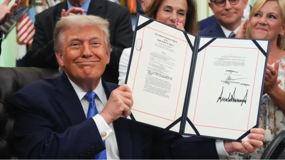 President Donald Trump holds up the "Secure America Act" after signing it in the Oval Office of the White House on June 10, 2026. (Ken Cedeno/AFP via Getty Images)