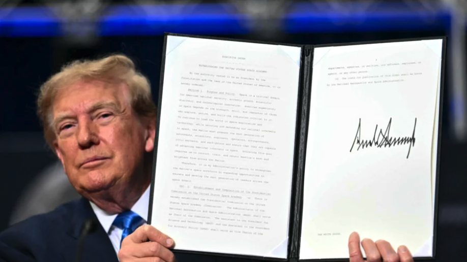 President Donald Trump holds up an executive order establishing a new U.S. Space Academy after signing it during a Congressional Space Medal of Honor presentation at NASA's Lyndon B. Johnson Space Center in Houston, Texas, on Aug. 28, 2026. (Kent Nishimura/AFP via Getty Images)